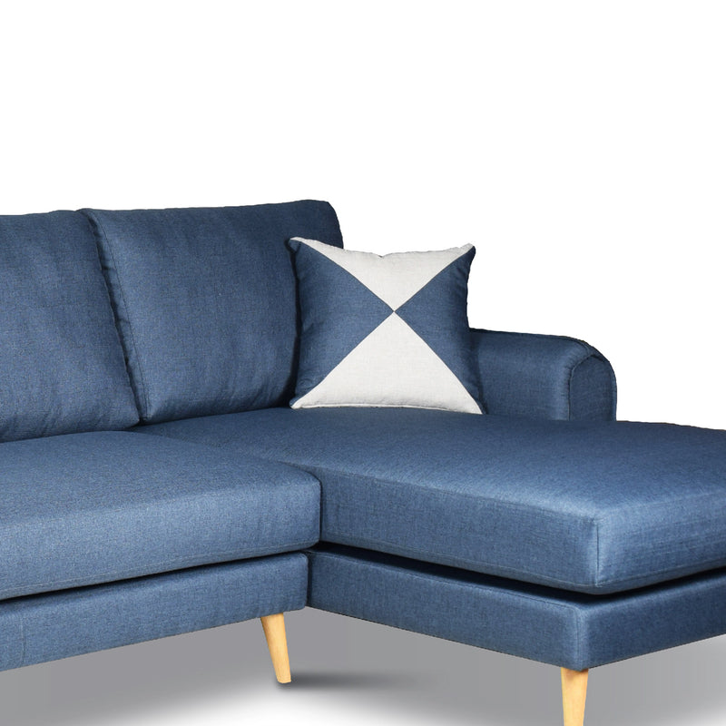 Blue sectional sofa with a decorative pillow on a white background