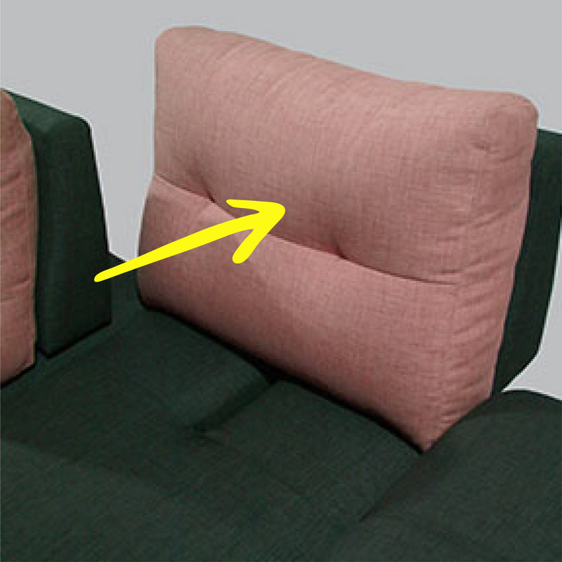 Pink cushion on a green sofa with a yellow arrow pointing to it.
