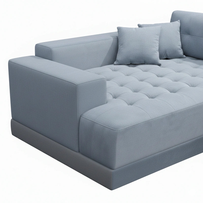 Gray tufted sofa with cushions on a white background