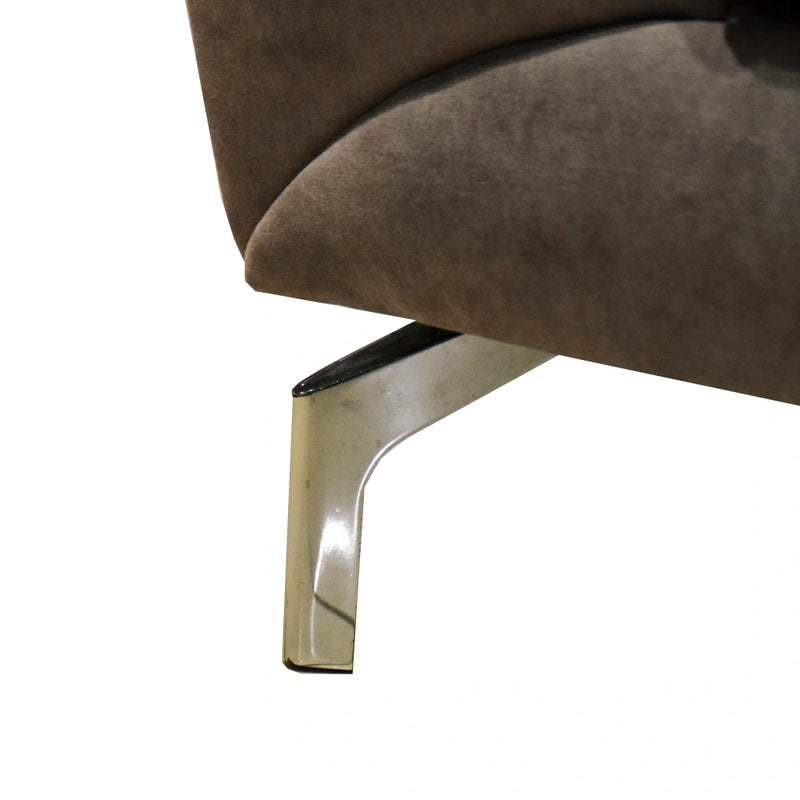Close-up of a brown upholstered chair with a shiny metal leg on a white background