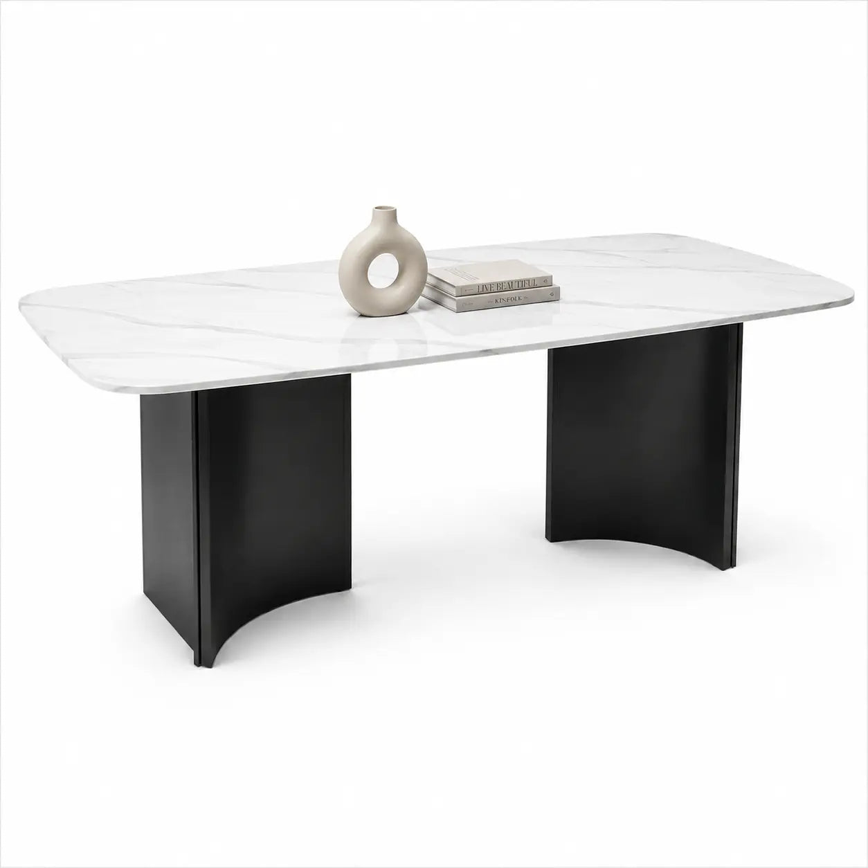 A modern rectangular console table with a white marble-look top and two black curved pedestal bases, styled with a small beige vase and books on top, set against a plain white background.