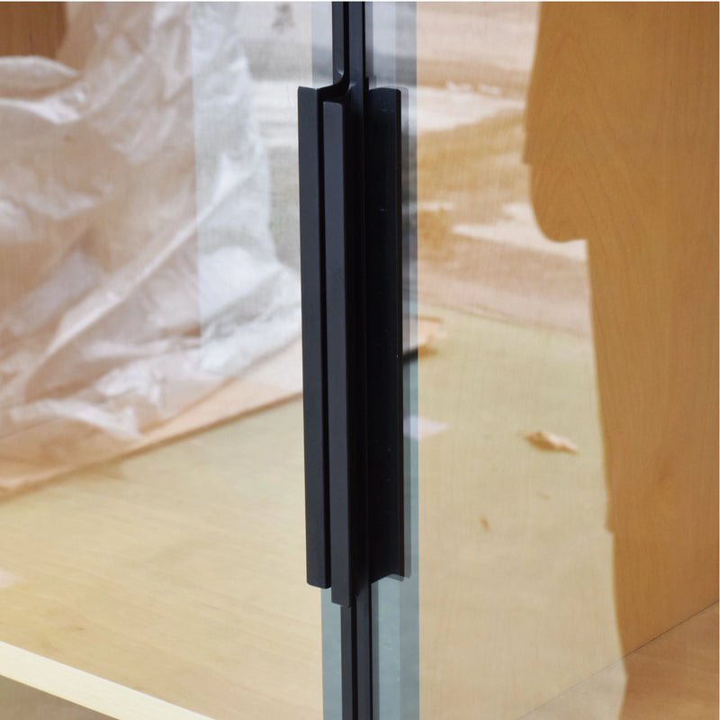Glass door with a black handle on a wooden floor