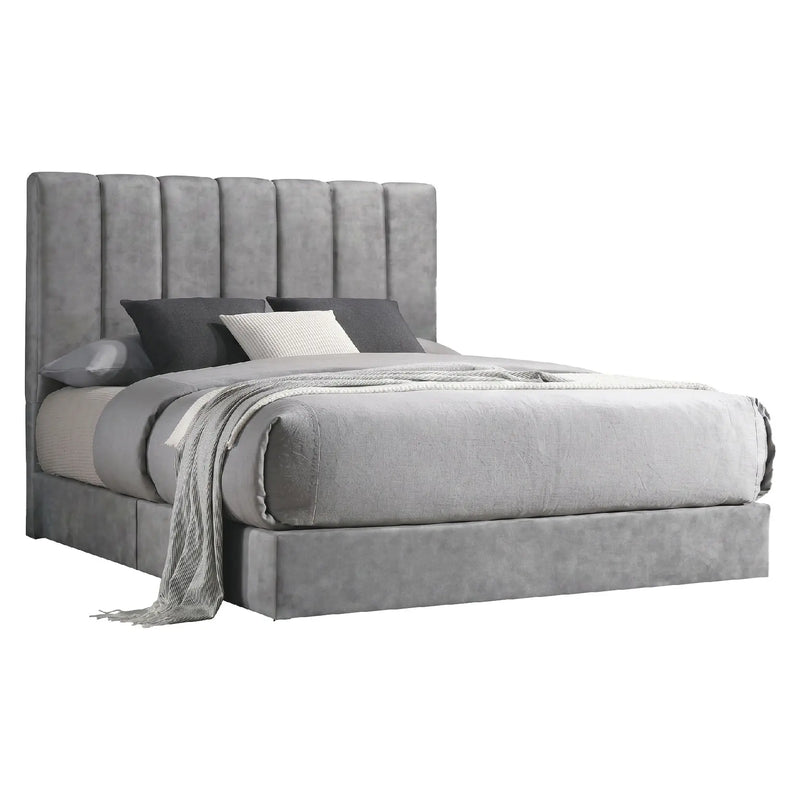 Gray upholstered bed with pillows and a blanket on a white background