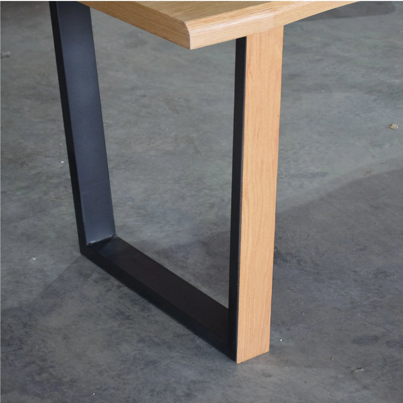 Wooden table with black metal legs on a concrete floor