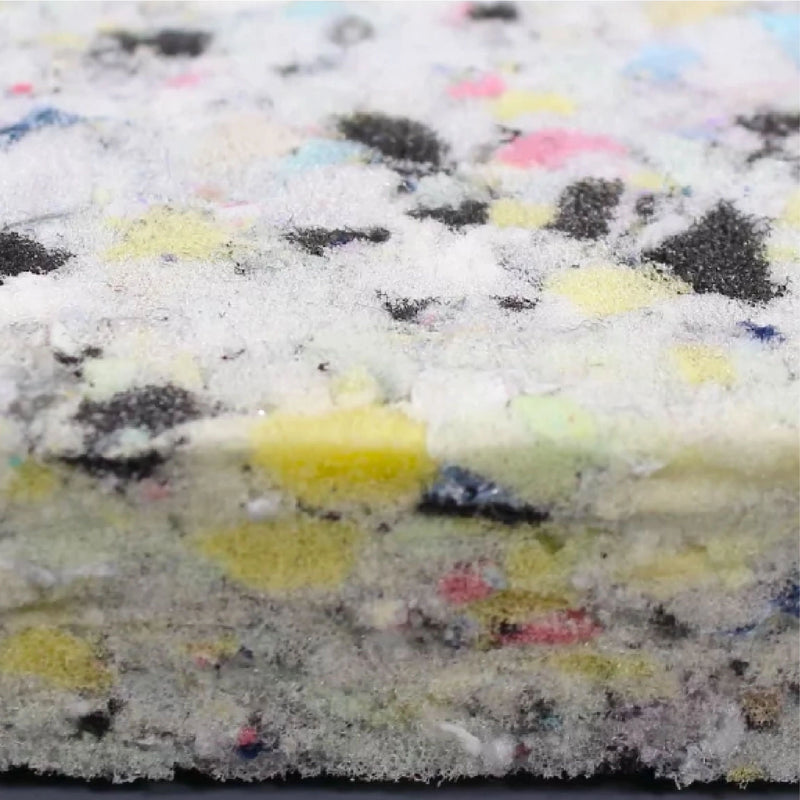 Multicolored foam block with black specks on a white background