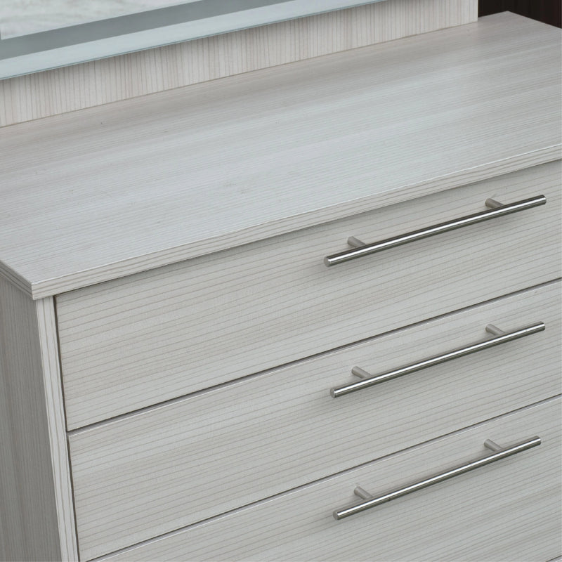 Close-up of a dresser with light gray finish and silver handles