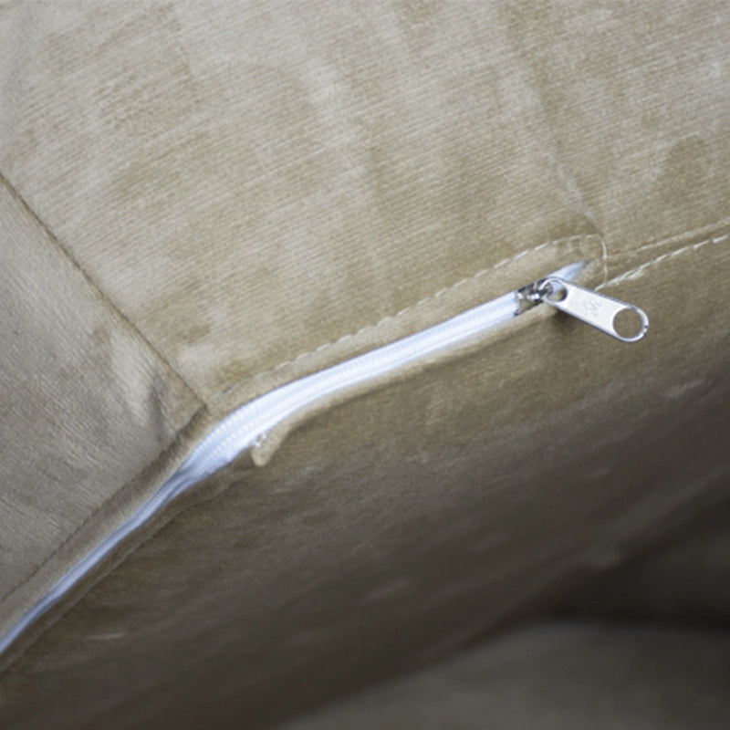 Close-up of a zipper on a beige fabric surface