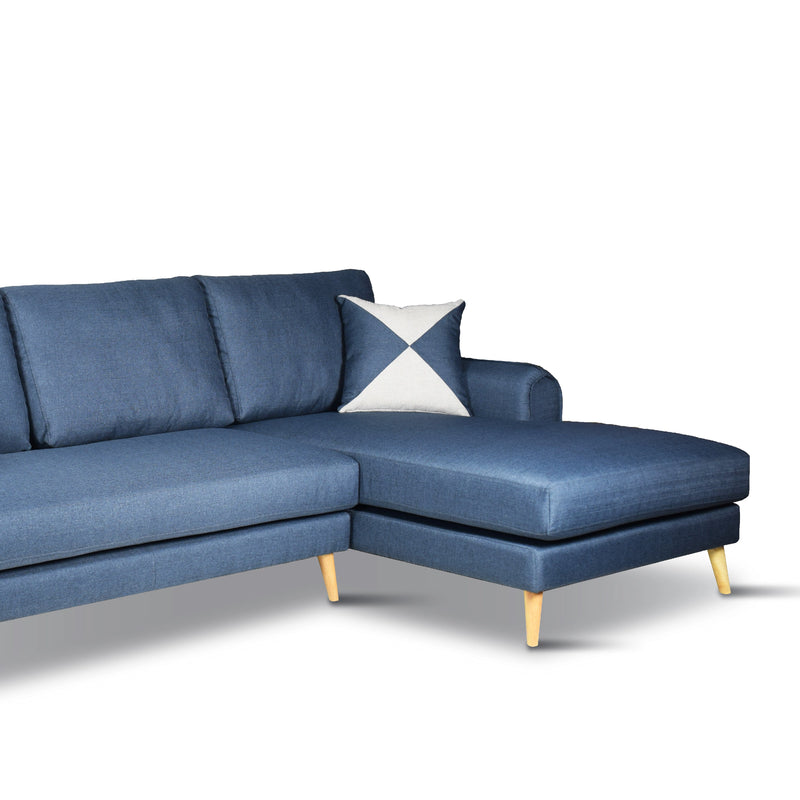 Blue sectional sofa with a decorative pillow on a white background