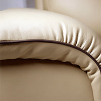 Close-up of a beige leather armchair with a brown trim.
