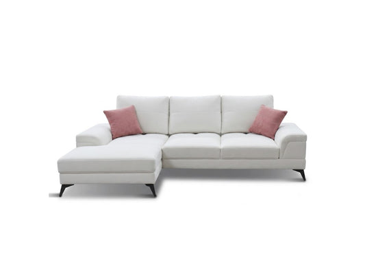 A modern white sectional sofa with a left-facing chaise lounge, accented by two dusty pink throw pillows and supported by slim black legs