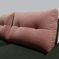 Close-up of a pink upholstered headboard on a bed with a gray background