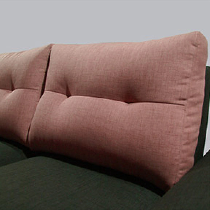 Close-up of a pink upholstered headboard on a bed with a gray background