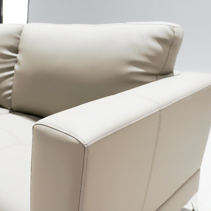 Beige leather sofa with a pillow