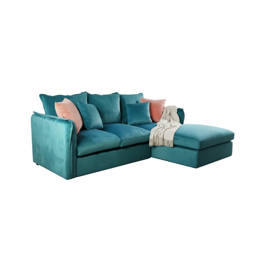 Teal sectional sofa with pink cushions and a blanket on a white background