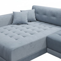 Gray sectional sofa with tufted cushions on a white background