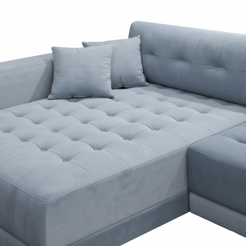 Gray sectional sofa with tufted cushions on a white background