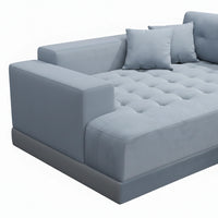 Gray tufted sofa with cushions on a white background