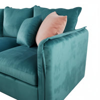 Teal sofa with pink pillow on a white background