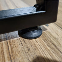 Close-up of a metal footrest on a wooden floor