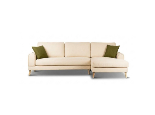 A modern three-seater sofa in a warm cream fabric with two olive green accent pillows and light wood legs, shown against a plain white background.