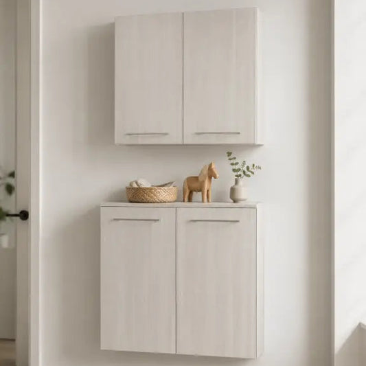 A pair of light beige wall-mounted cabinets with a matching countertop, styled with a basket, wooden horse figurine, and small vase in a bright, minimalist room.