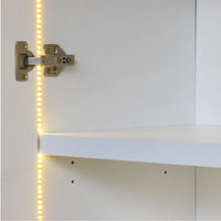 Cabinet hinge with LED strip light on a white cabinet