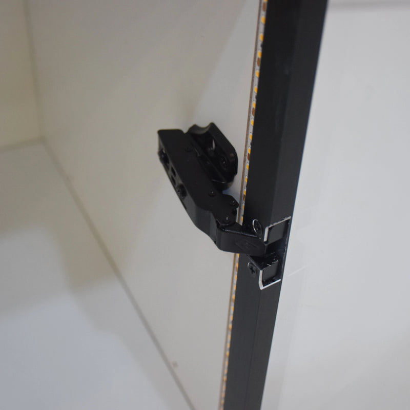 Close-up of a black cabinet handle on a white cabinet door.