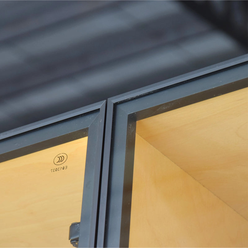Close-up of a window frame with a metallic finish and wooden interior.