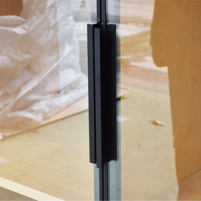 Glass door with a black handle on a wooden floor
