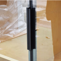 Glass door with a black handle on a wooden floor