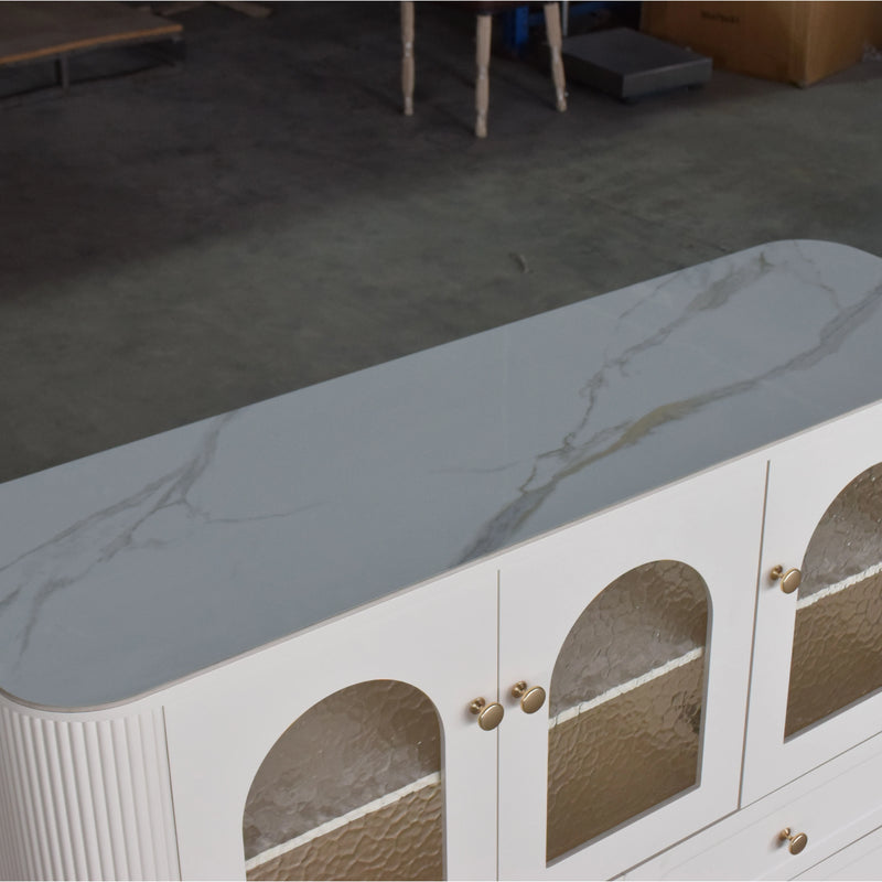 Modern white cabinet with marble-like top and glass panels in a room setting.