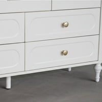 White dresser with gold knobs on a gray floor