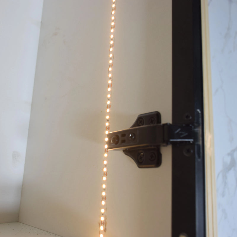 Close-up of a door hinge with LED strip lighting on a white background