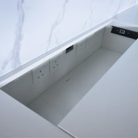 Underbed storage compartment with electrical outlets on a white bed frame.