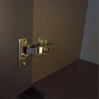 Close-up of a gold cabinet hinge on a brown door