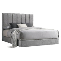 Gray upholstered bed with pillows and a blanket on a white background