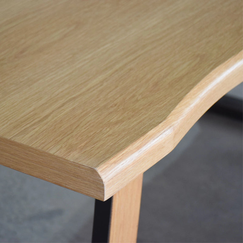 Close-up of a wooden table corner with a blurred background