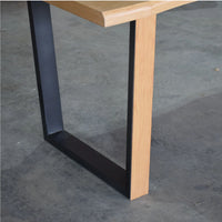 Wooden table with black metal legs on a concrete floor