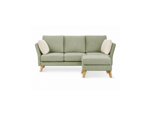 A three-seat sofa with a right-facing chaise lounge, upholstered in a sage green fabric, featuring two cream throw pillows and light-colored wooden legs, shown against a plain white background.