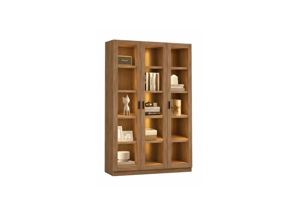 A tall wooden bookcase with three glass-front doors and open shelves, shown against a plain white background. The bookcase is styled with books, decorative objects, and small plants.
