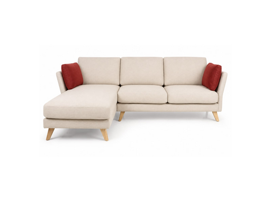 A modern three-seater sofa with a left-facing chaise lounge, upholstered in a light beige fabric, supported by light wood legs and accented with two red throw pillows, shown against a plain white background.