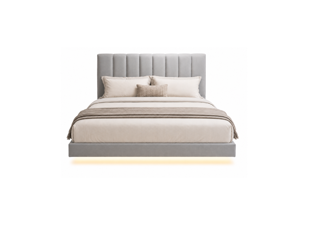 A modern platform bed with a tall, vertically channel-tufted headboard upholstered in light gray fabric, styled with neutral beige and white bedding, pillows, and a matching throw blanket. A warm glow of under-bed lighting is visible against a solid white background.