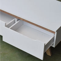 White desk with a wooden top and open drawer on a green floor.