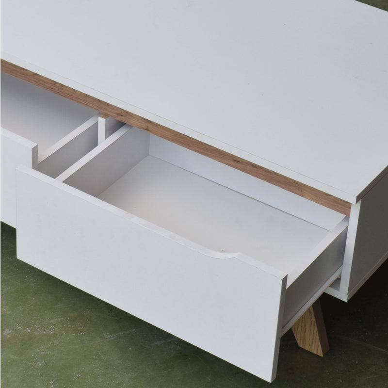 White desk with a wooden top and open drawer on a green floor.