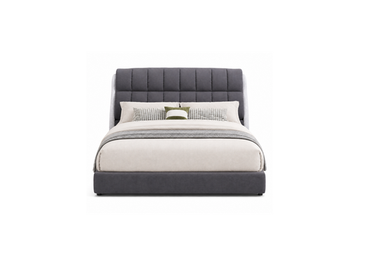 A modern platform bed with a tall, vertically channel-tufted headboard and matching footboard in dark gray fabric, styled with off-white bedding and two accent pillows on a plain white background.