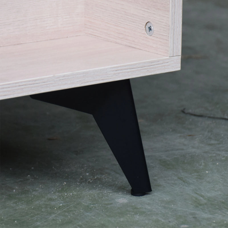 Close-up of a wooden cabinet leg on a concrete floor