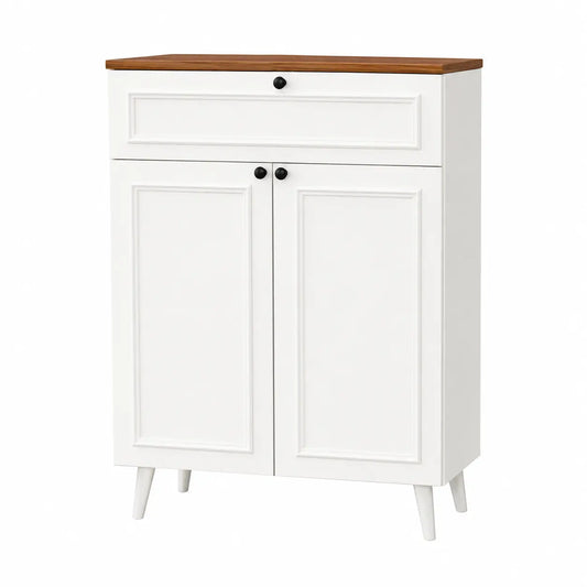 A white two-door storage cabinet with a single drawer on top, featuring a medium brown wood-look countertop, black round knobs, and tapered white legs, shown on a plain white background.