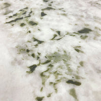 Close-up of a white surface with green leafy patterns