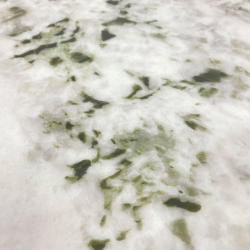 Close-up of a white surface with green leafy patterns
