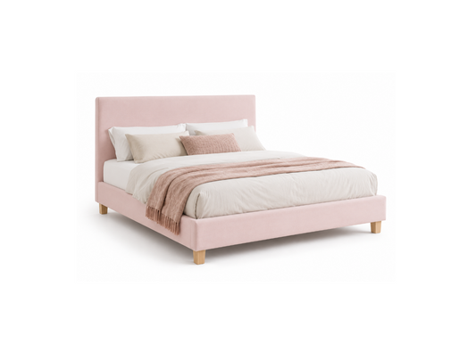 A light pink upholstered bed frame with a matching headboard, styled with white bedding, beige pillows, and a pink throw blanket, shown on a solid white background.